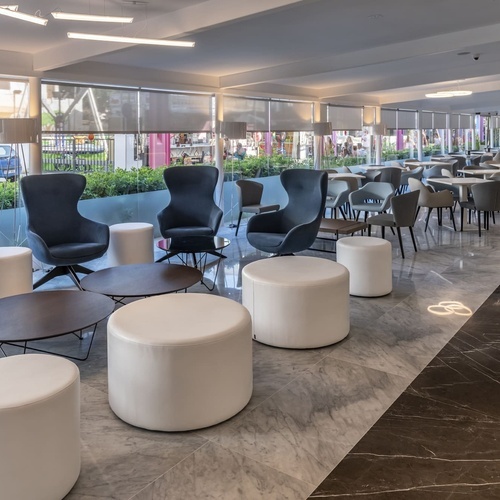 una sala de estar con sillas y mesas y un logotipo en el suelo