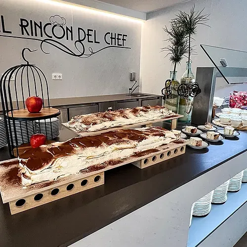 Olympus Palace: Langer cremiger Kuchen mit Kakaopulver am Buffet.