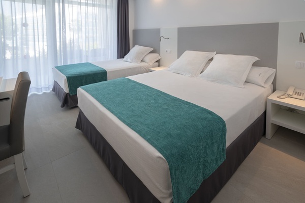 una habitación de hotel con dos camas y una mesa