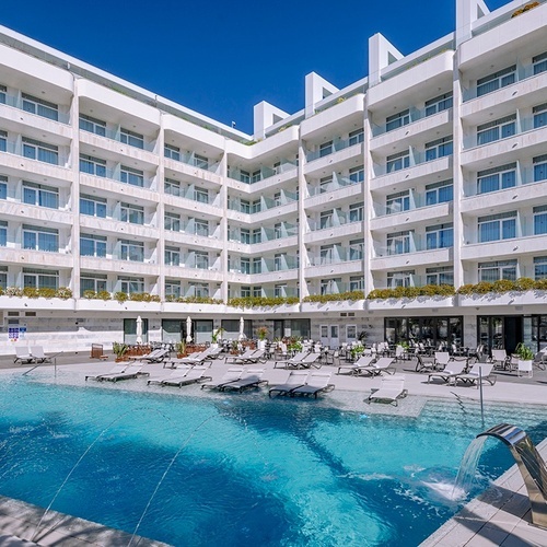 un gran edificio blanco con una piscina al frente