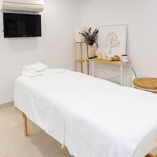 una habitación con una cama de masaje y una televisión