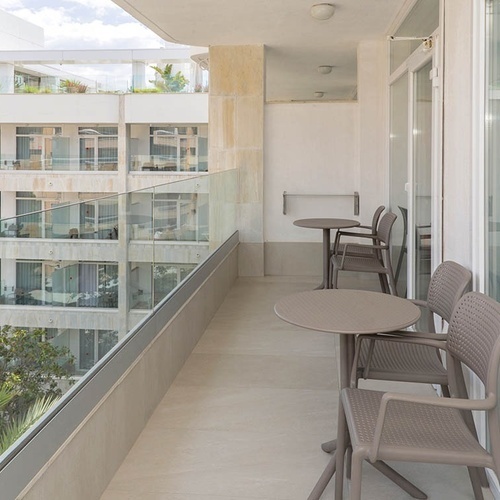 un balcón con mesas y sillas frente a un edificio