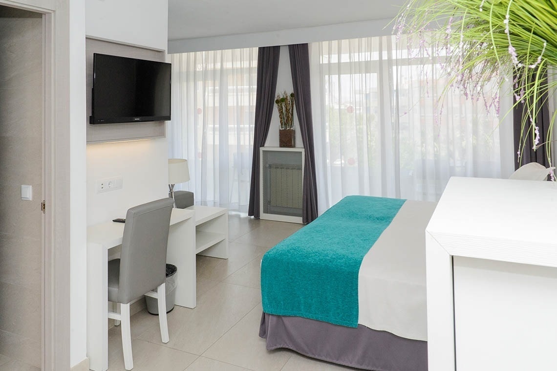 una habitación de hotel con una cama y una televisión