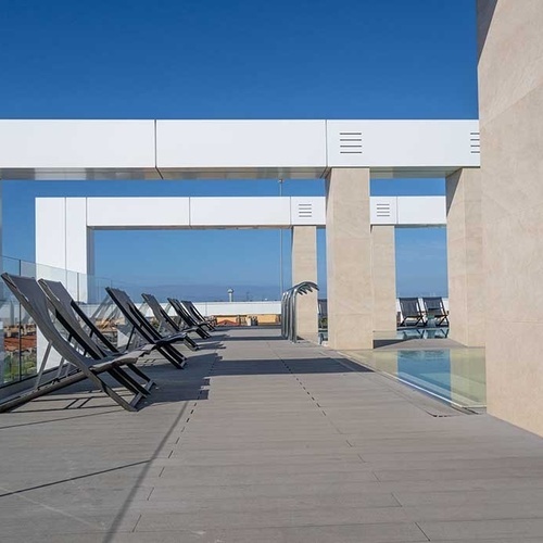 una terraza con sillas y una piscina en el fondo