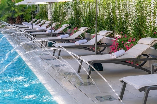 a row of lounge chairs next to a swimming pool