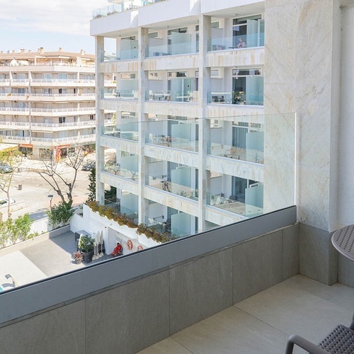 un balcón con una mesa y sillas frente a un edificio de apartamentos