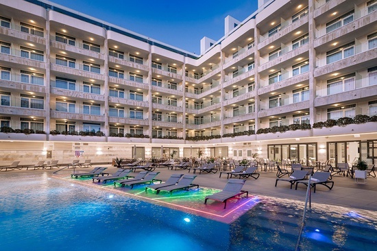 a large building with a swimming pool in front of it