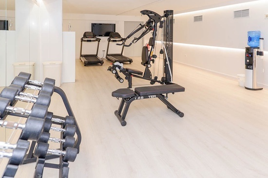 a gym with treadmills and a bench that says las ter