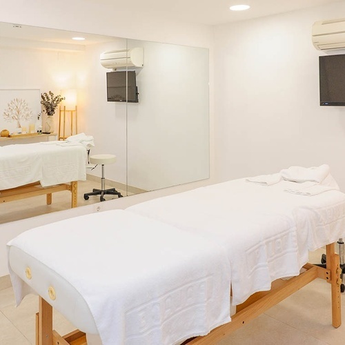 una habitación con una cama de masaje y una televisión