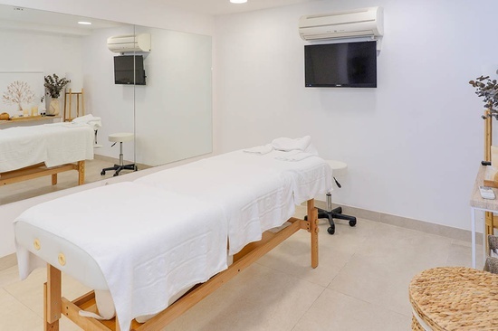 a massage table in a room with a tv on the wall
