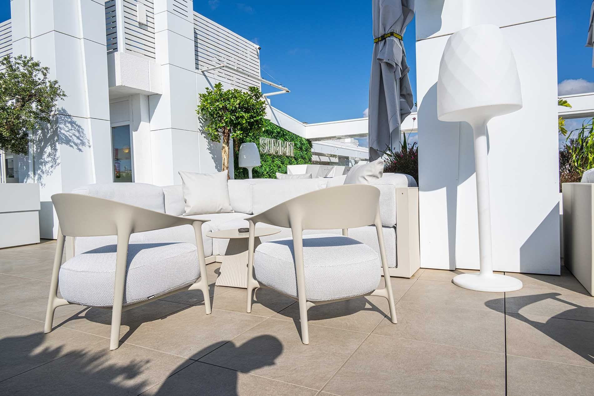 Terrasse moderne de l'Olympus Palace avec canapé, chaises et lampe d'extérieur.