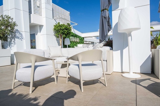 a white chair sits in front of a white couch