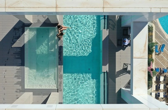 an aerial view of a swimming pool with a woman in it