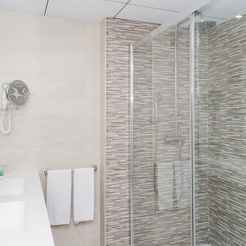 un baño con dos lavabos y una ducha de vidrio