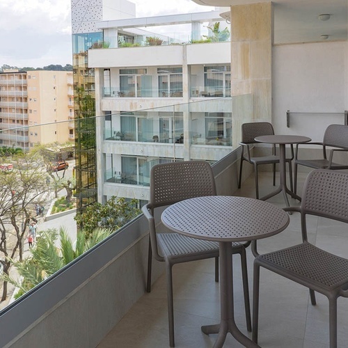 un balcón con mesas y sillas y una vista de la ciudad