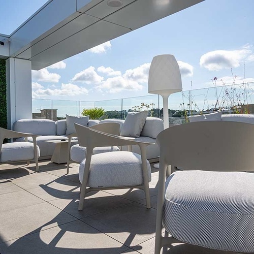 una terraza llena de muebles y una lámpara