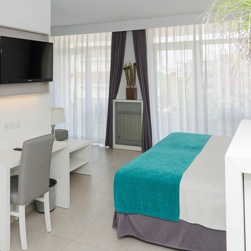 una habitación de hotel con una cama y una televisión