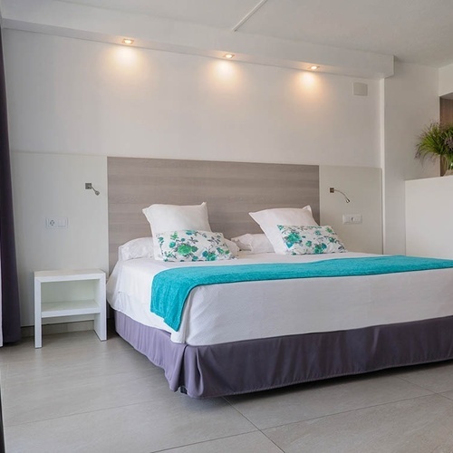 una habitación de hotel con una cama y una mesita de noche