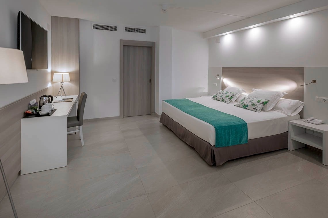 una habitación de hotel con una cama y un escritorio