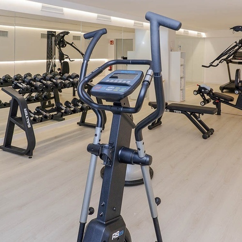 un gimnasio con muchos equipos y una bicicleta de ejercicio