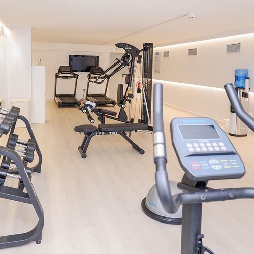 un gimnasio con una bicicleta y una cinta de correr