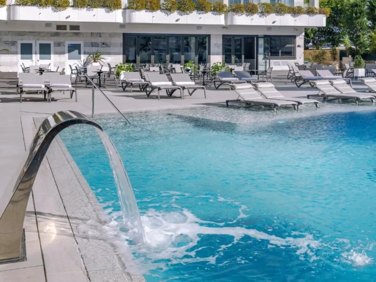 Piscina con cascada en Olympus Palace, ideal para relajarse.