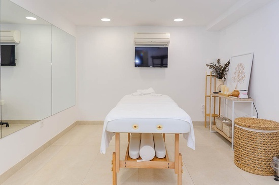 a massage table in a room with a tv on the wall