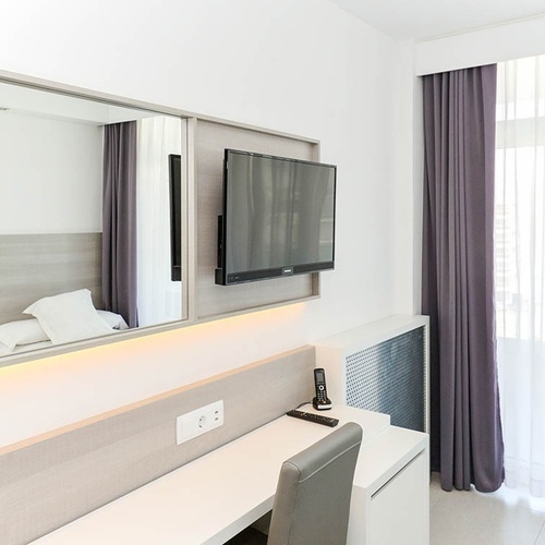 una habitación de hotel con un televisor y un escritorio