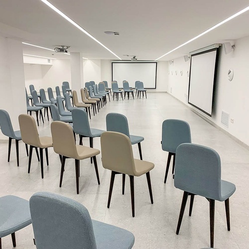 una habitación llena de sillas y una pantalla de proyección