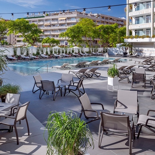 una piscina rodeada de mesas y sillas en un hotel