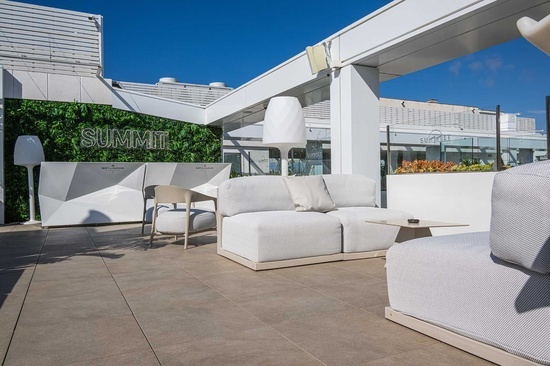 una terraza con muebles blancos y un letrero que dice summit