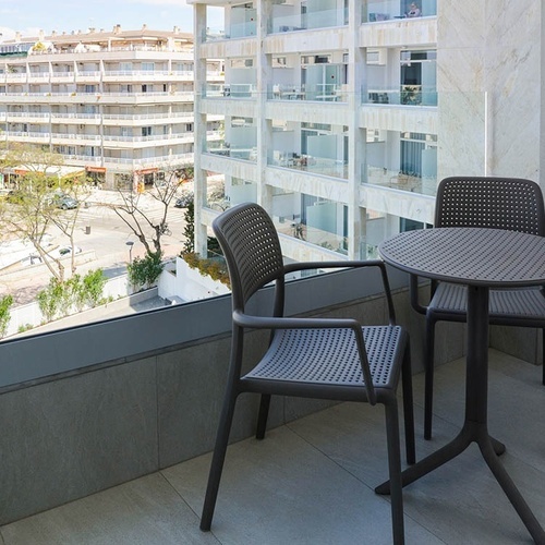 una mesa y dos sillas en un balcón con vistas a un edificio