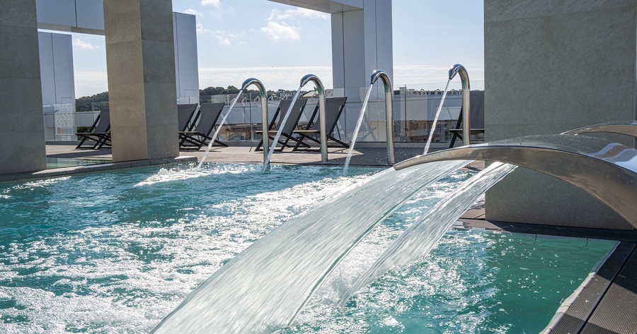 a swimming pool with a waterfall coming out of it