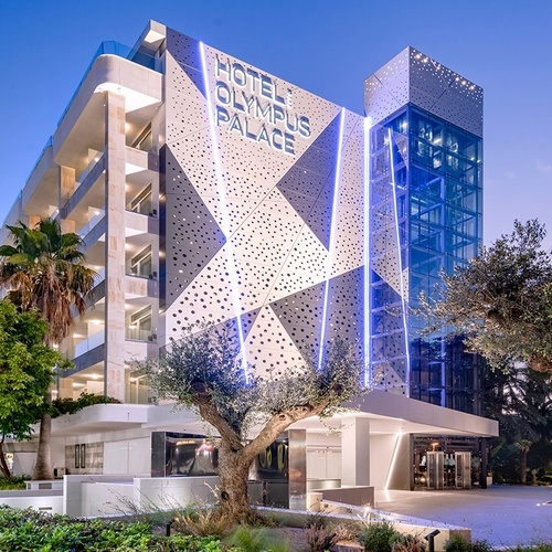 el edificio del hotel olympus palace está iluminado por la noche