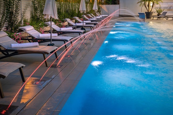 a swimming pool with chairs and umbrellas around it