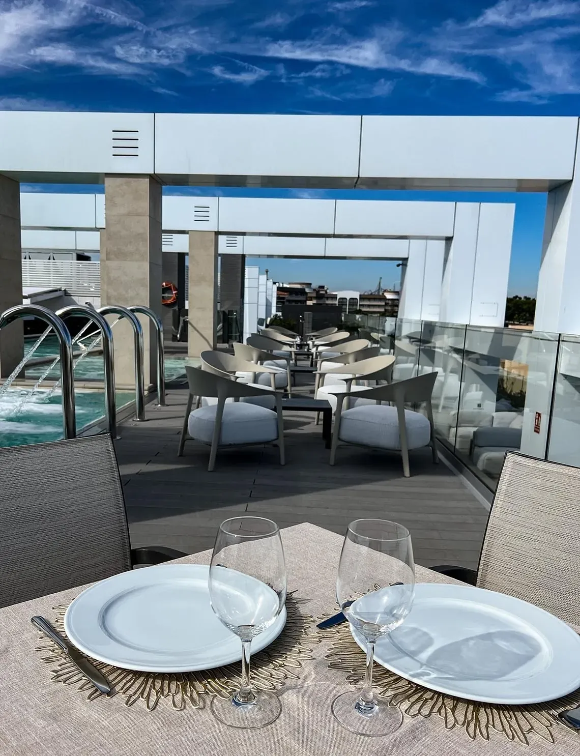 Terraza Olympus Palace: mesas elegantes junto a la piscina con vistas.