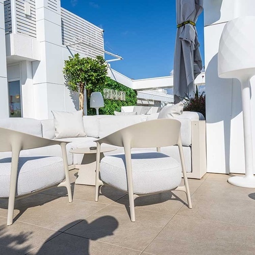 dos sillas blancas están junto a una mesa y una lámpara blanca