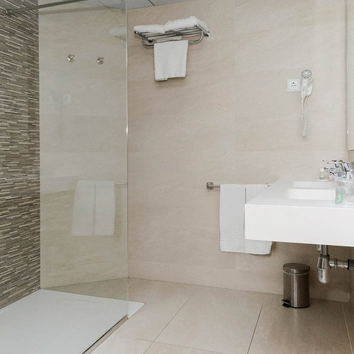 un baño con un lavabo y una ducha de vidrio