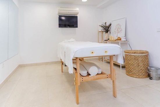 a massage table in a room with a tv above it