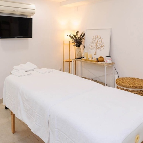 una habitación con una cama de masaje y una televisión