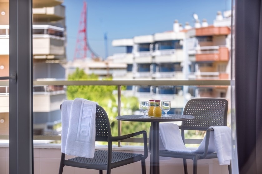 un balcón con una mesa y dos sillas y una botella de zumo de naranja