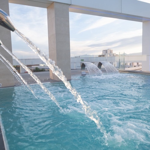 una piscina con fuentes y una señal de advertencia de peligro