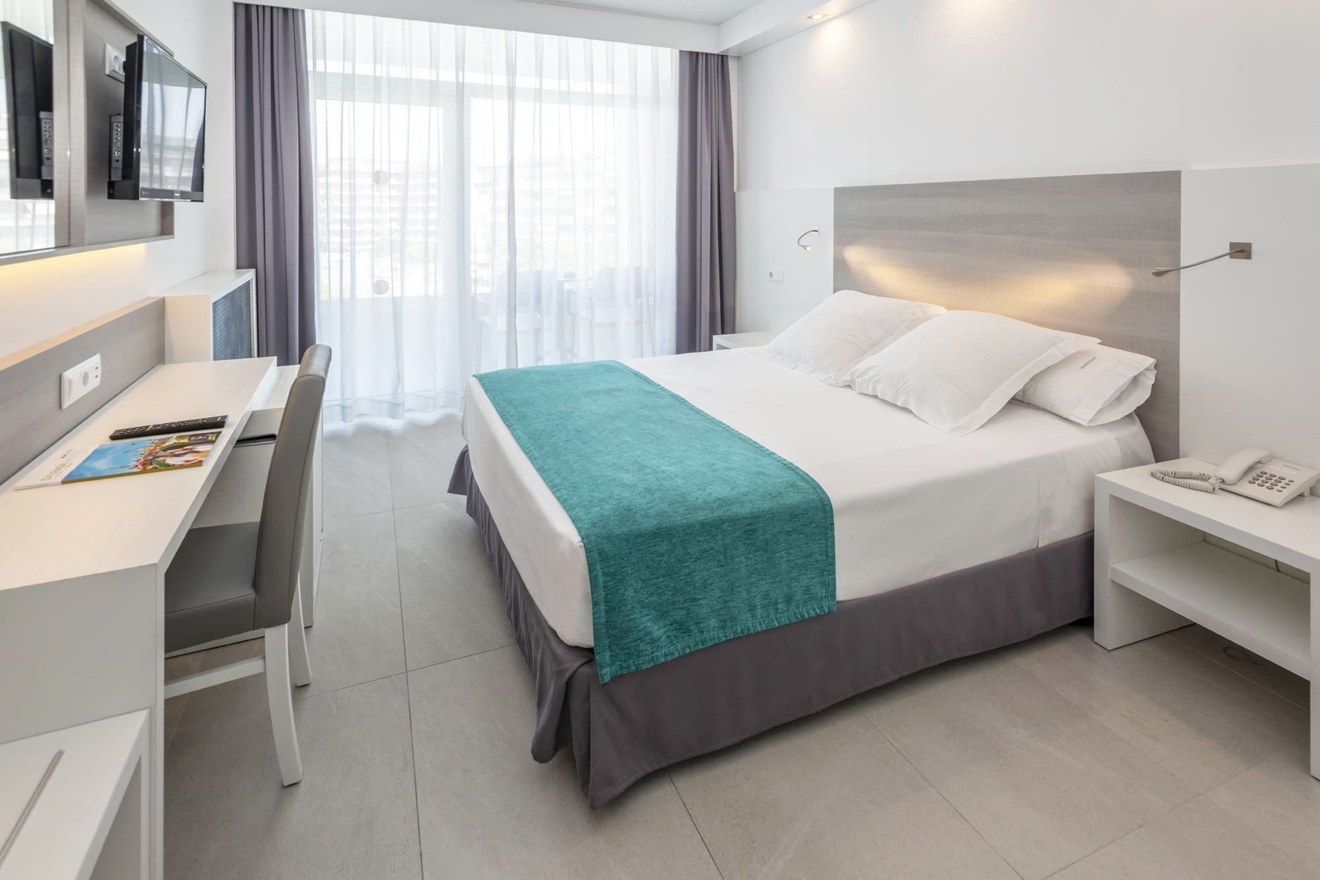 una habitación de hotel con una cama y un escritorio