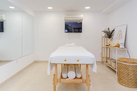 a massage table in a room with a tv above it