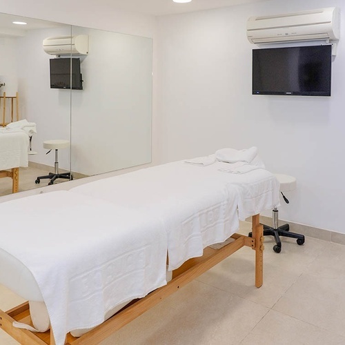 una habitación con una cama de masaje y una televisión