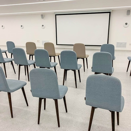 una habitación llena de sillas y una pantalla de proyección