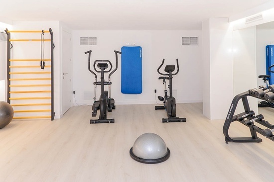 a gym with exercise bikes and a ball with the word pilates on it
