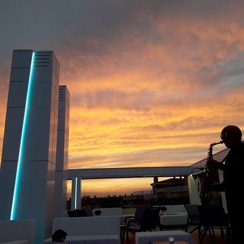 un hombre tocando un saxofón al atardecer
