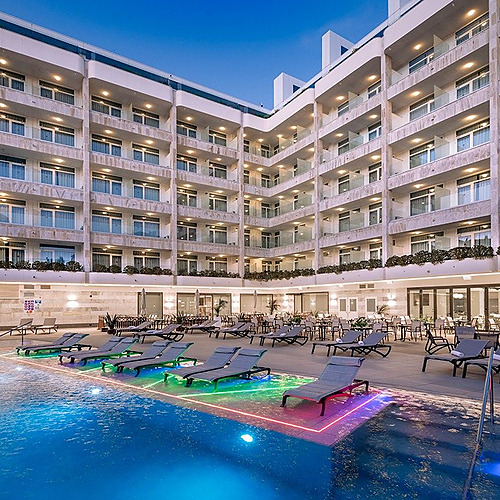 Hotel Olympus Palace: beleuchteter Pool und Liegen auf der Terrasse.
