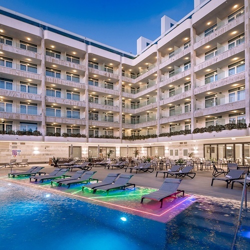 una gran piscina rodeada de sillas y mesas en un hotel